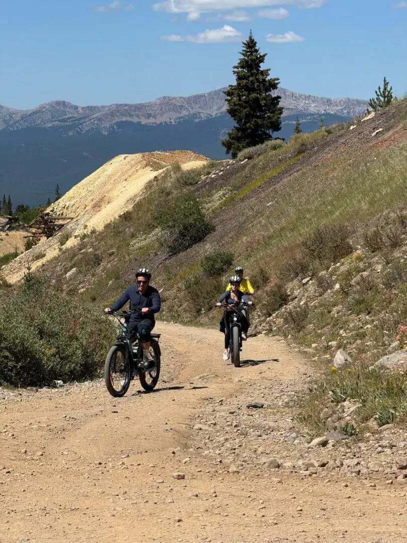 Two people riding bikes on a dirt road.