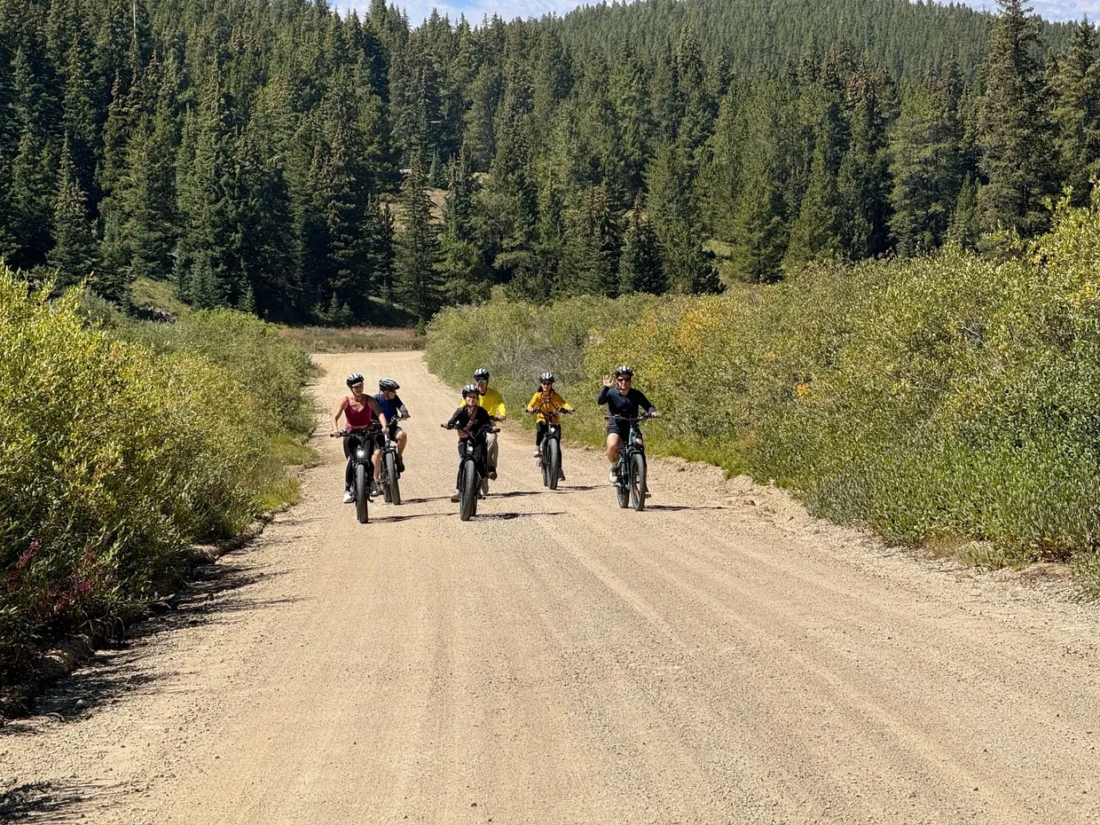 A group of people riding bikes on a dirt road.