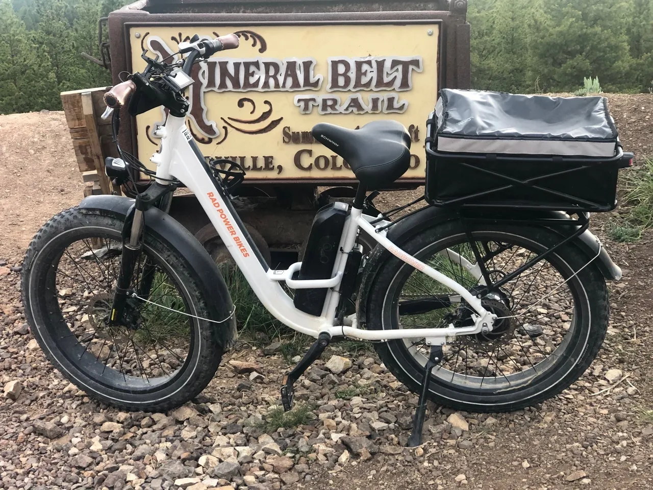 A white bike parked in front of a sign.