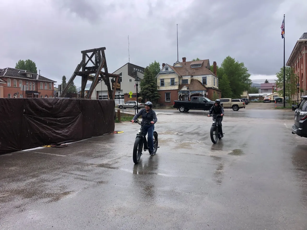 Two people riding motorcycles in a flooded area.