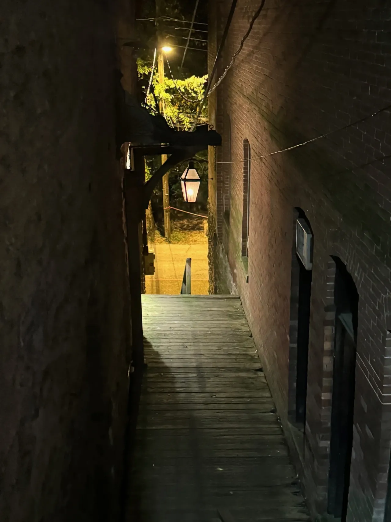 A narrow alley way with lights on the side.