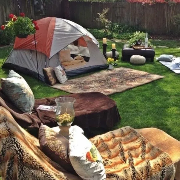 A tent and some pillows in the grass.