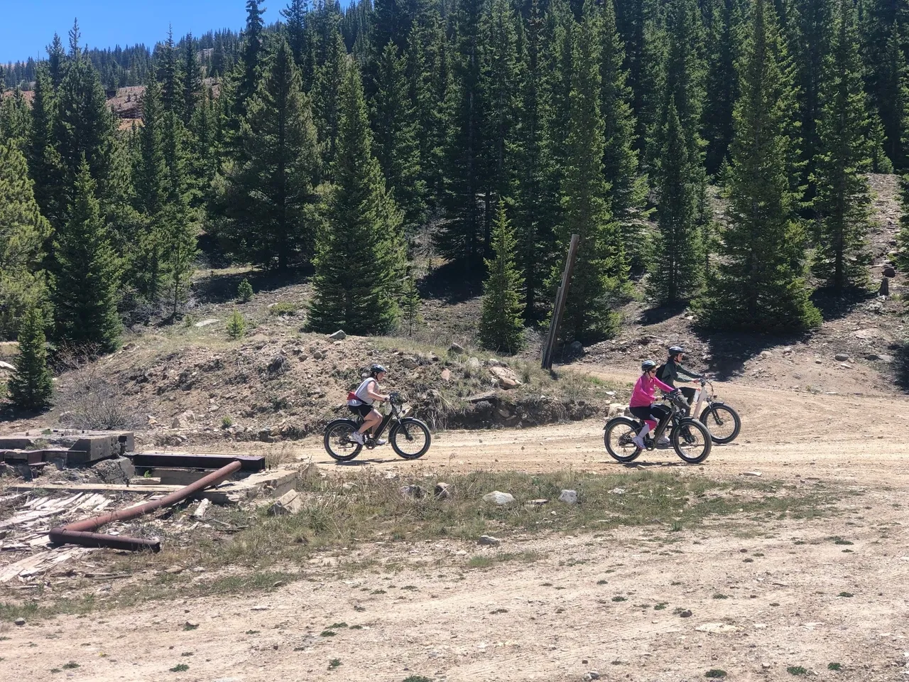 Two people riding bikes on a dirt road.