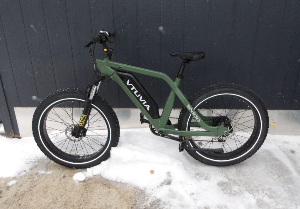 Green electric bike in snowy environment.