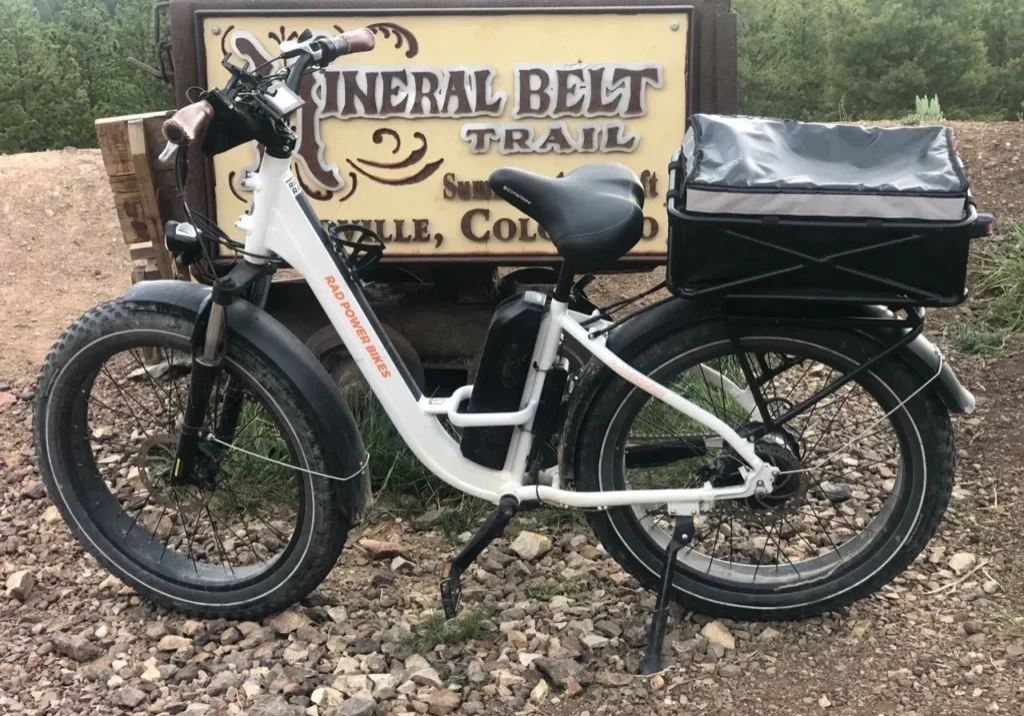 A white bike parked in front of a sign.